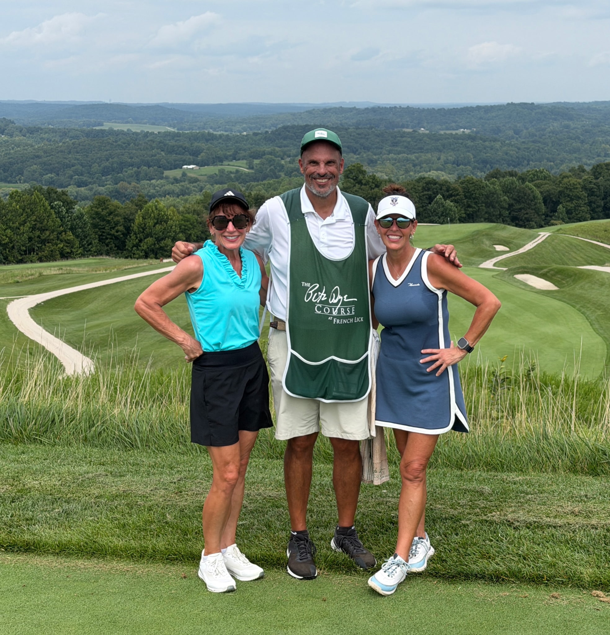 Janet and Linda with their caddie — the Pete Dye Course rolling away behind them
